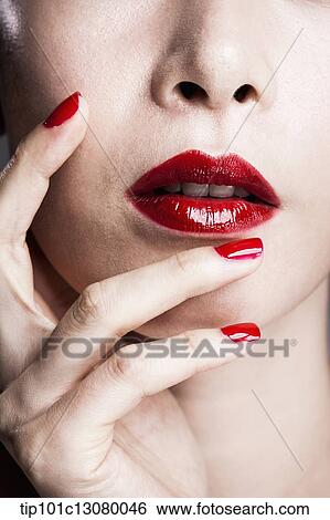 hand with red nail polish on woman's face with red lipstick View Large Photo Image Stock Photograph - hand with red nail polish on woman's face with red lipstick . Fotosearch