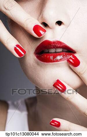 hands with red nail polish on woman's face with red lipstick View Large Photo Image Picture - hands with red nail polish on woman's face with red lipstick . Fotosearch