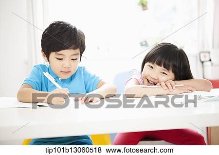 Stock Photo - kids at desk learning together. Fotosearch