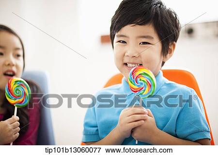 Stock Photo - kids eating lollypops. Fotosearch