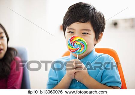 Stock Photograph - kids eating lollypops. Fotosearch