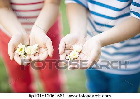 Stock Image - kids holding a couple of flowers. Fotosearch