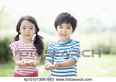 Stock Image - kids holding a couple of flowers. Fotosearch