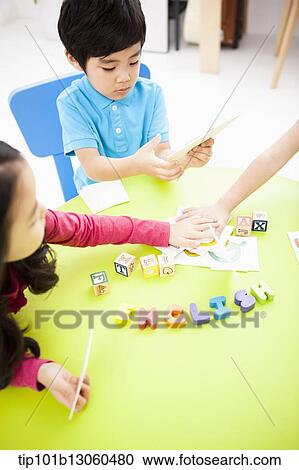 Stock Image - kids learning English with toys at table. Fotosearch