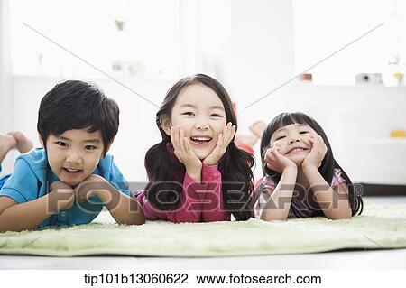kids lying in the floor carpet with hands under their chin View Large Photo Image Stock Image - kids lying in the floor carpet with hands under their chin. Fotosearch