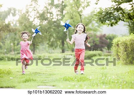 Stock Image - kids playing with a toy wind mills. Fotosearch