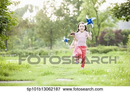 Stock Photo - kids playing with a toy wind mills. Fotosearch