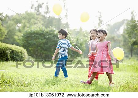 Stock Image - kids playing with balloons. Fotosearch