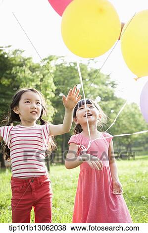 Stock Photo - kids playing with balloons. Fotosearch