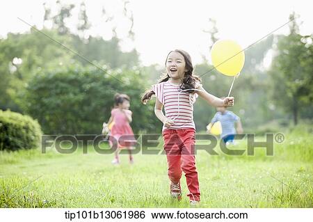 Stock Photograph - kids playing with balloons. Fotosearch