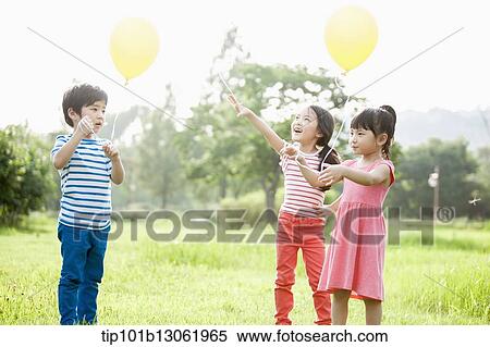 Stock Photography - kids playing with balloons. Fotosearch