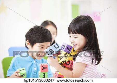 Stock Photo - kids playing with toy cubes on a table. Fotosearch