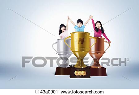 Stock Image - kids raising their hands while standing inside trophies. Fotosearch