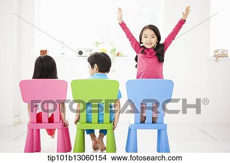 Picture - kids sitting on chairs. Fotosearch