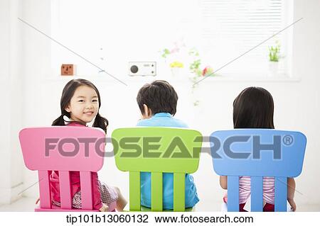 Stock Image - kids sitting on chairs. Fotosearch
