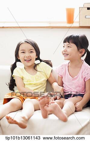 Stock Image - kids sitting on couch. Fotosearch