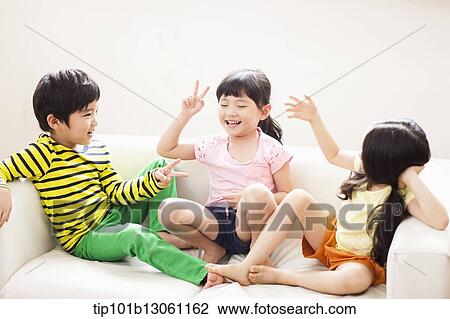 Stock Image - kids sitting on couch. Fotosearch