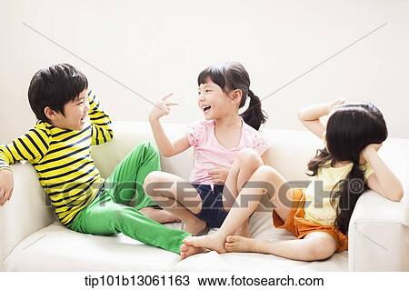 Stock Image - kids sitting on couch. Fotosearch