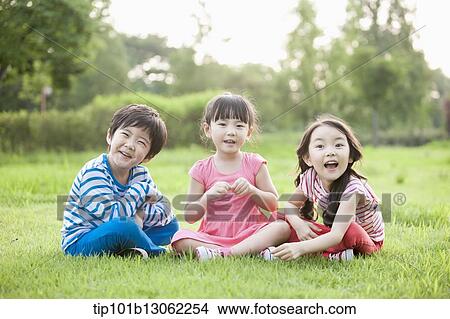 Picture - kids sitting on the grass. Fotosearch