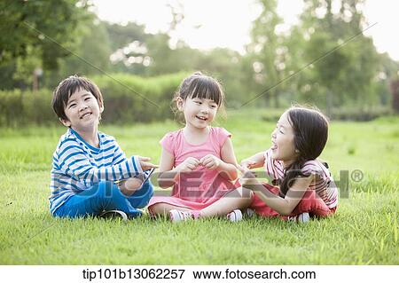 kids sitting on the grass View Large Photo Image Stock Photo - kids sitting on the grass. Fotosearch