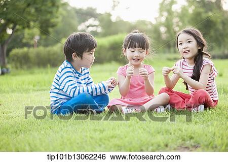 Stock Photograph - kids sitting on the grass. Fotosearch