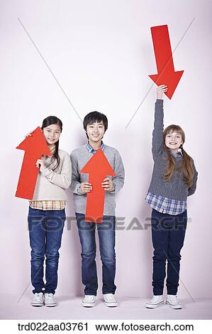 Stock Image - kids standing and holding red arrows. Fotosearch