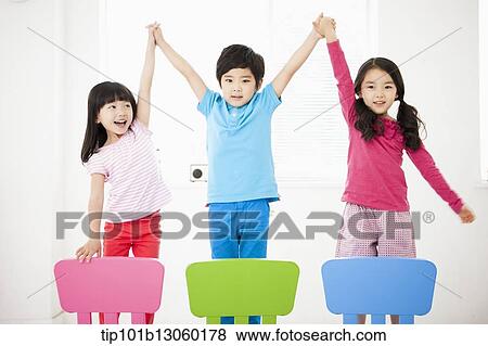 Stock Photo - kids standing on chairs. Fotosearch