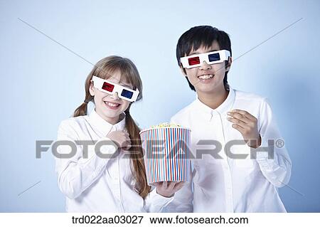 kids watching a 3d movie with popcorn View Large Photo Image Stock Photo - kids watching a 3d movie with popcorn. Fotosearch