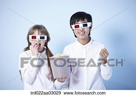 kids watching a 3d movie with popcorn View Large Photo Image Stock Photo - kids watching a 3d movie with popcorn. Fotosearch
