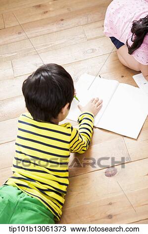 Stock Image - kids writing into a book. Fotosearch