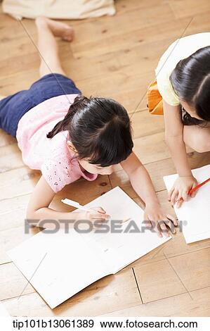 Stock Photo - kids writing into a book. Fotosearch