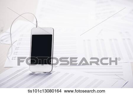 Picture - mobile phone on musical papers. Fotosearch