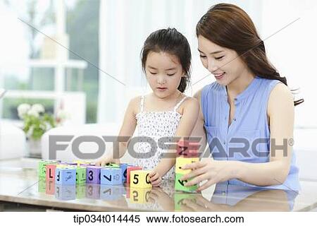 Stock Photography - mother and daughter playing with toy blocks . Fotosearch