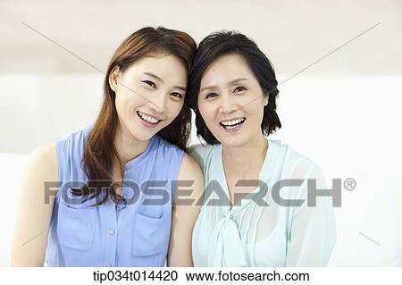Stock Image - mother and grown up daughter smiling together. Fotosearch