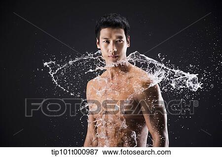Stock Photo - side shot of a fit man in black background with water splash. Fotosearch