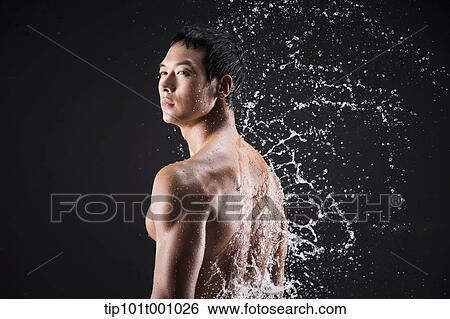 Stock Photograph - side shot of a fit man in black background with water splash. Fotosearch