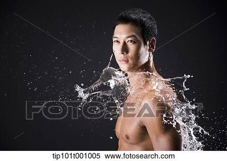 Stock Photography - side shot of a fit man in black background with water splash. Fotosearch