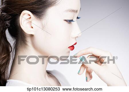 Stock Image - side shot of a woman in red lipsticks on. Fotosearch
