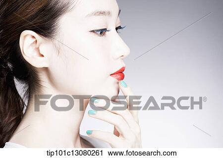 Stock Image - side shot of a woman in red lipsticks on. Fotosearch