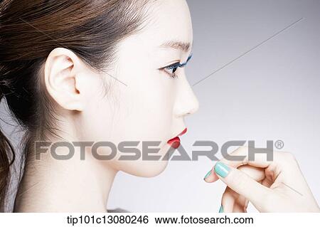 Stock Photograph - side shot of a woman in red lipsticks on. Fotosearch