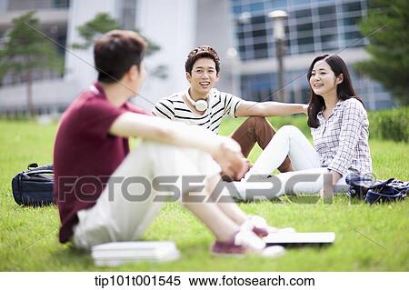 Stock Photography - students sitting on grass having a conversation. Fotosearch