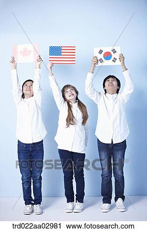 Stock Image - three kids holding different flags. Fotosearch