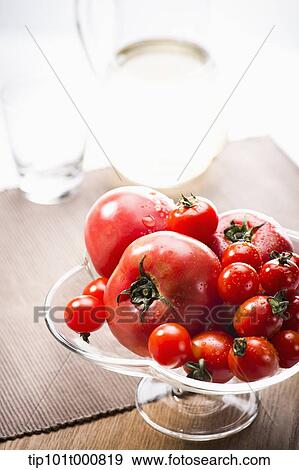 Stock Photo - tomatoes on a glass fruit plate . Fotosearch
