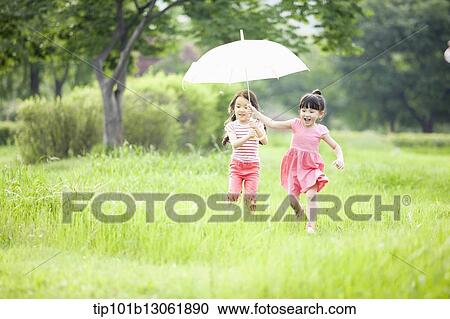 two girls walking with an umbrella View Large Photo Image Stock Image - two girls walking with an umbrella. Fotosearch