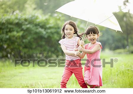 two girls walking with an umbrella View Large Photo Image Stock Image - two girls walking with an umbrella. Fotosearch