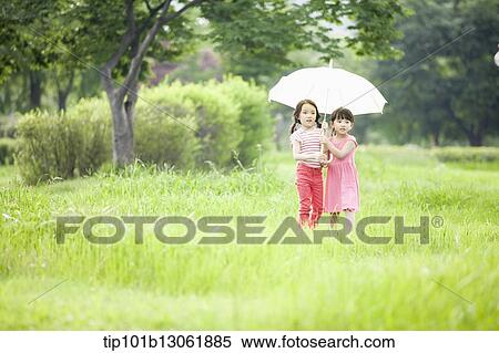 two girls walking with an umbrella View Large Photo Image Stock Photography - two girls walking with an umbrella. Fotosearch