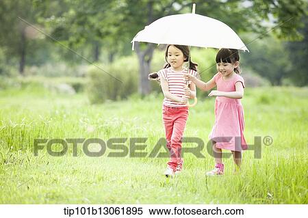 two girls walking with an umbrella View Large Photo Image Stock Photography - two girls walking with an umbrella. Fotosearch