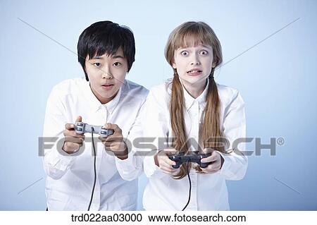 Stock Image - two kids playing a video game. Fotosearch