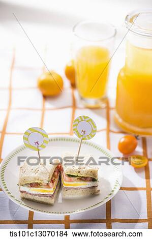 two sandwiches next to a glass of juice View Large Photo Image Picture - two sandwiches next to a glass of juice. Fotosearch