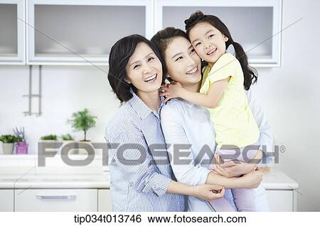 two woman and a child hugging in the kitchen View Large Photo Image Stock Photograph - two woman and a child hugging in the kitchen. Fotosearch
